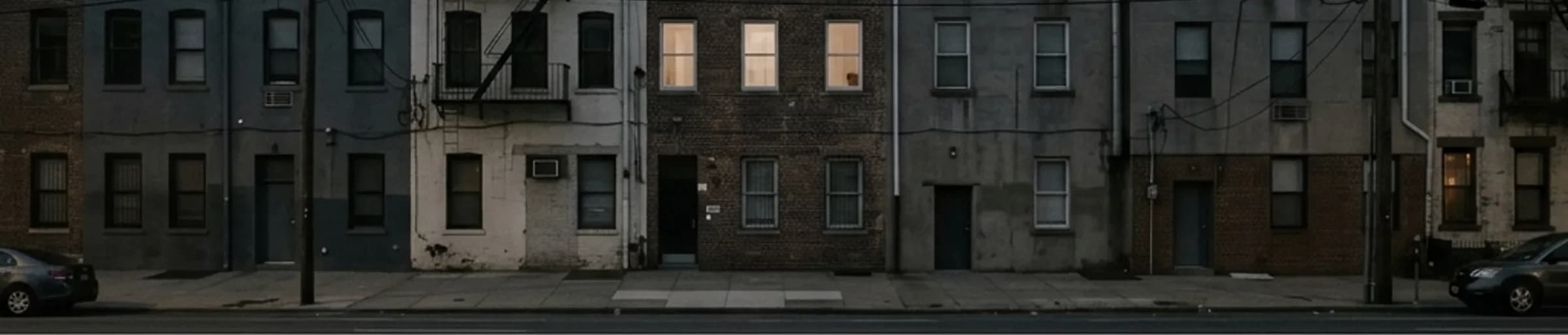 Anonymous building facades at dusk with a few windows lit.